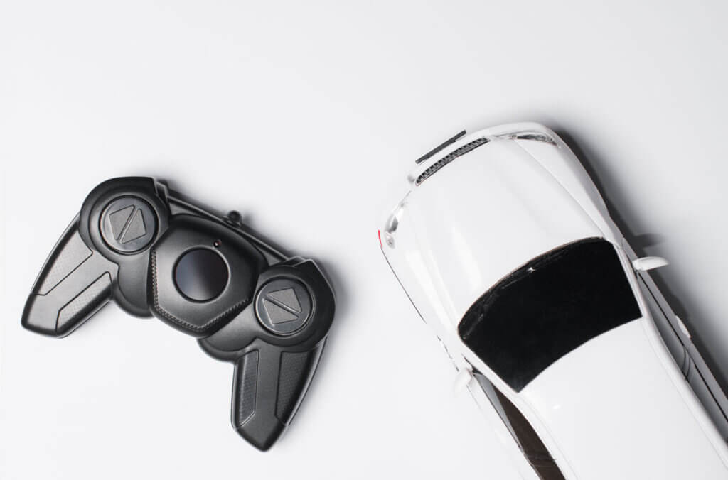 Radio-controlled toy car with remote control, top view, flat lay