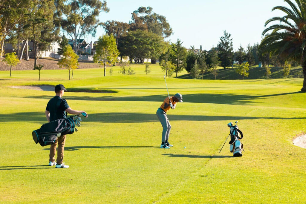 Golfer swinging a club on course