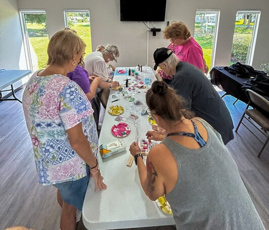 Residents make resin art crafts in the West Clubhouse at Rolling Greens Village in Ocala, Florida.