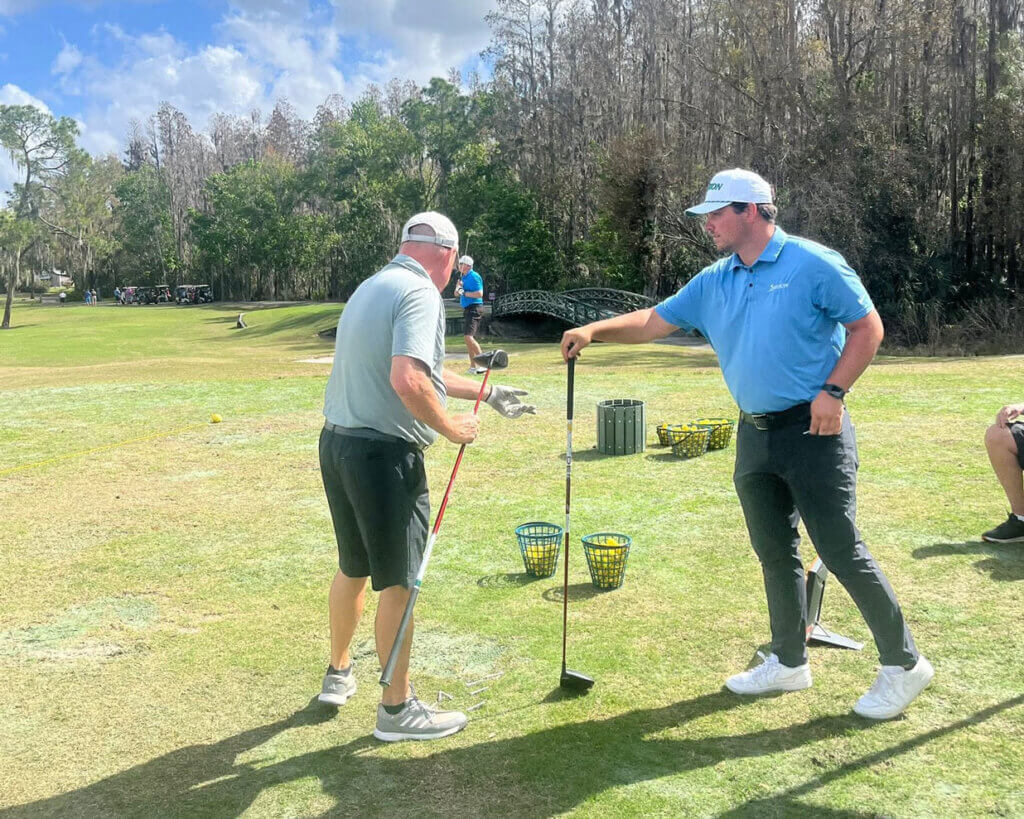 A man testing golf clubs during a Cypress Lakes Village demo day by Srixon. 