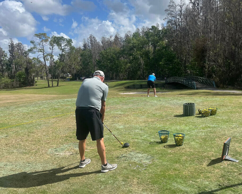 A man testing golf clubs during a Cypress Lakes Village demo day by Srixon.