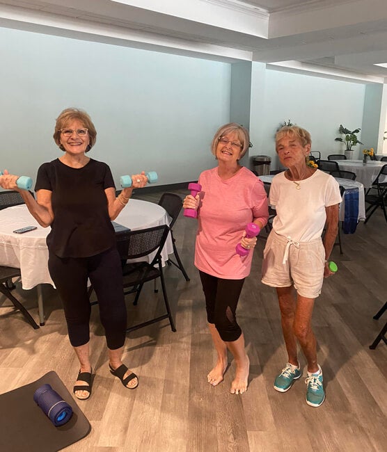 55+ residents holding dumb bell weights at Rolling Greens Village in Ocala, Florida.