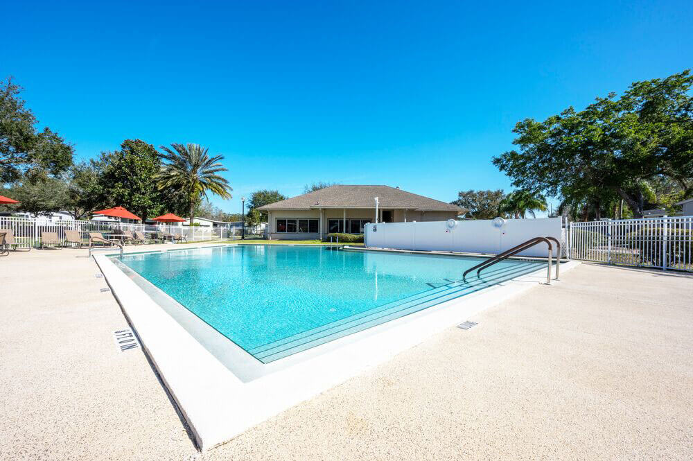 Swimming pool view with a clubhouse in the background at StrawBerry Ridge Village, a 55+ community outside of Tampa in Valrico, Florida.