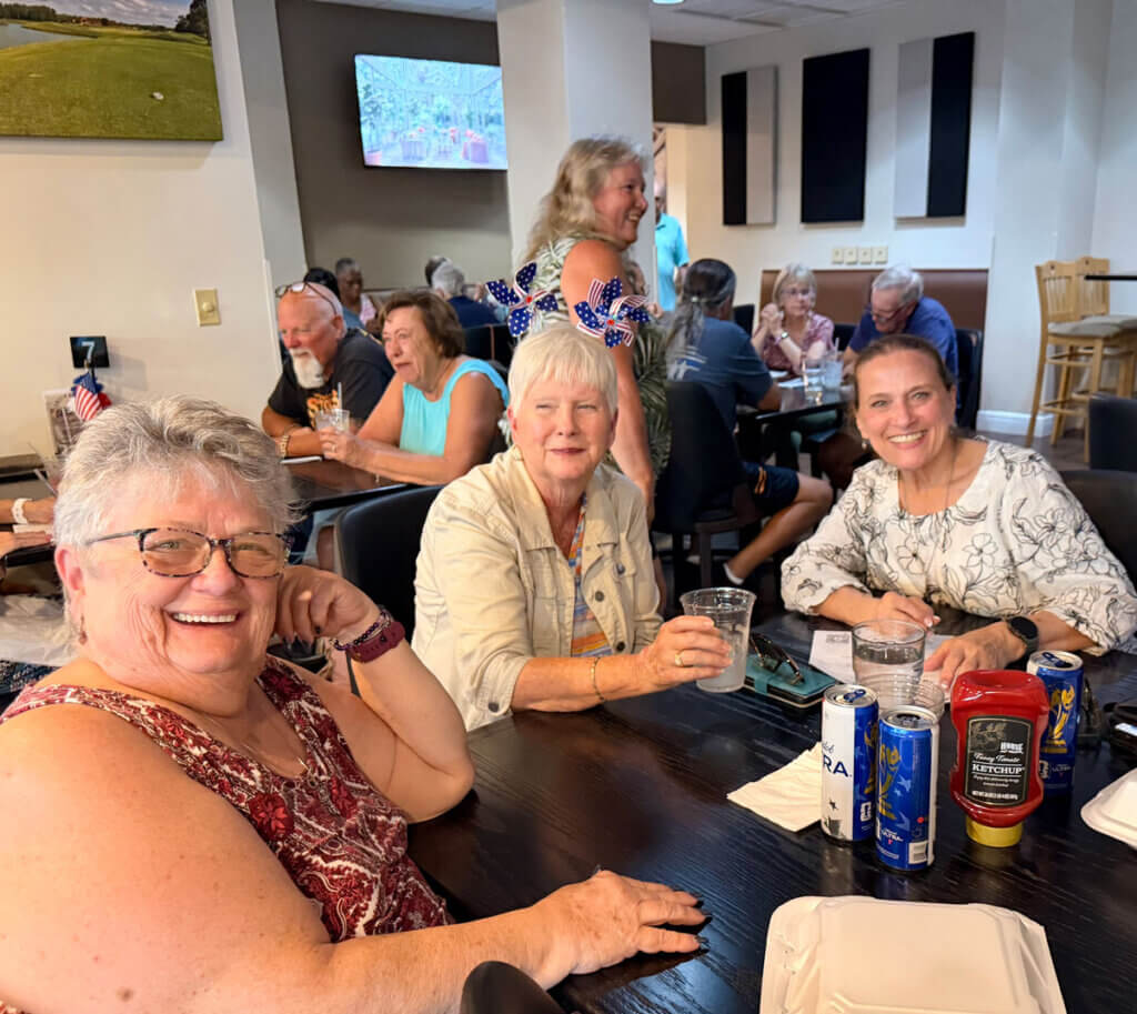 Three friends hanging out at a Big Cypress Grill table around drinks.