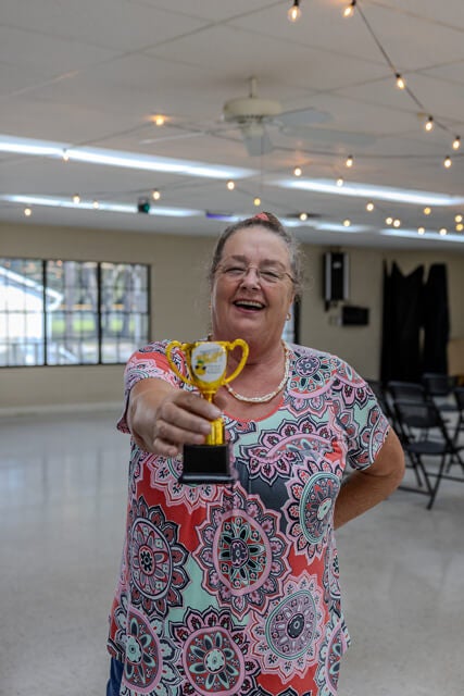Resident showing off her trophy from the Adult twisted Summer Camp Awards Ceremony at Holiday RV Park in Leesburg, Florida.