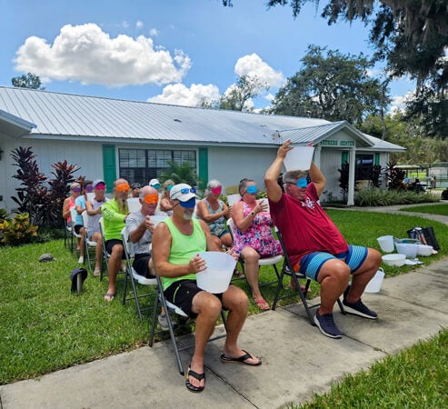 Residents and guests participating in water games during adult twisted summer camp at Holiday RV Park in Leesburg, Florida.