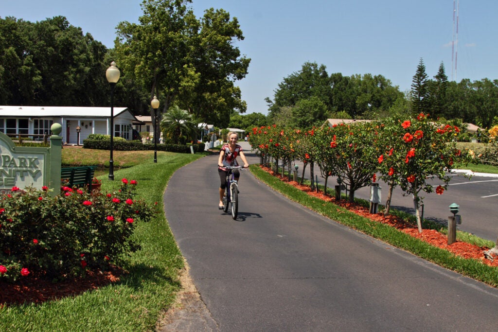 Woman riding bike along path