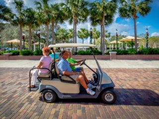 couple riding golf cart down Plant street in downtown winter garden 