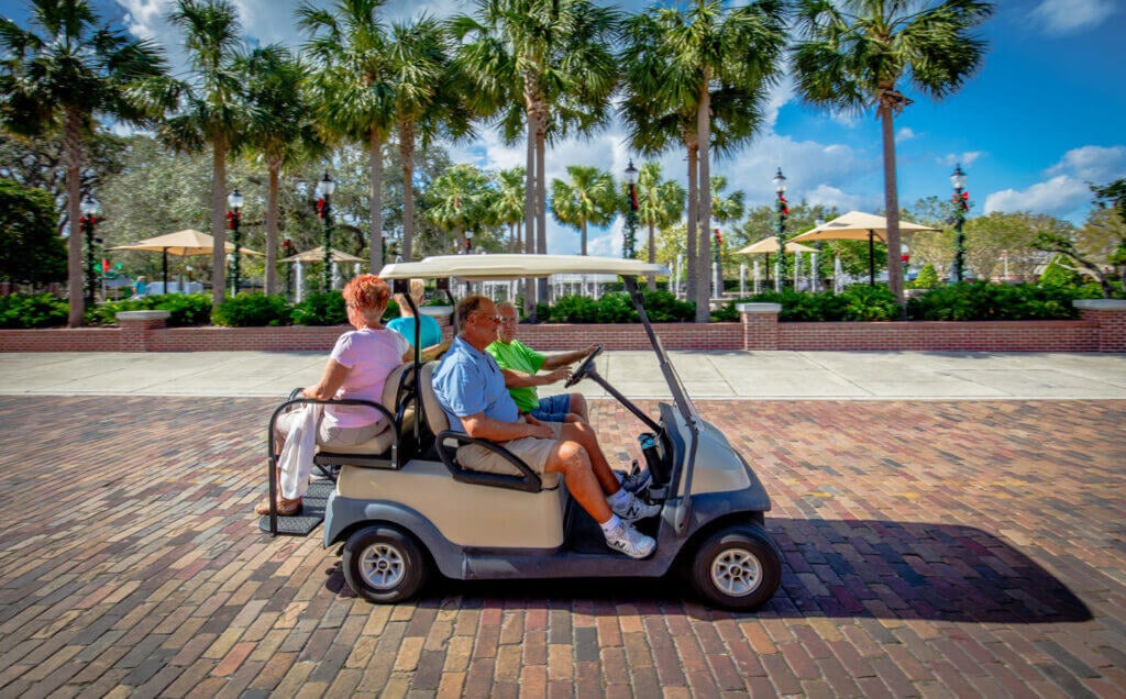 couple riding golf cart down Plant street in downtown winter garden 