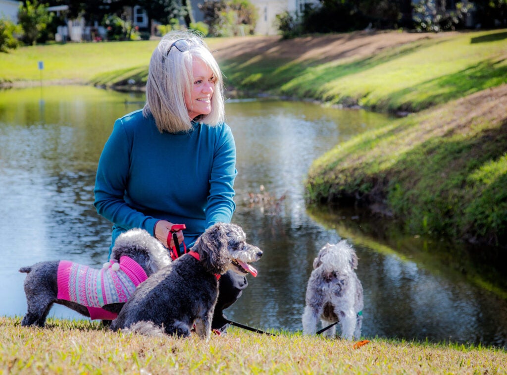 Resident with dogs by pond at Hyde park Village