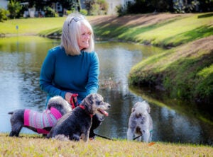 Resident with dogs by pond at Hyde park Village