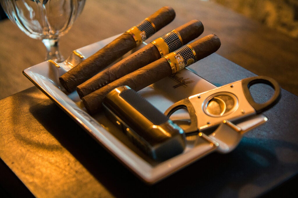 Cigars with cutter and lighter on ashtray