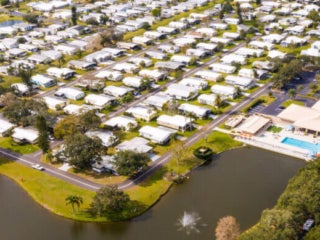Overhead view of Camelot Lakes Village's pond and manufactured homes.
