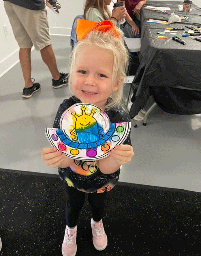 little girl holding alien / monster arts and crafts