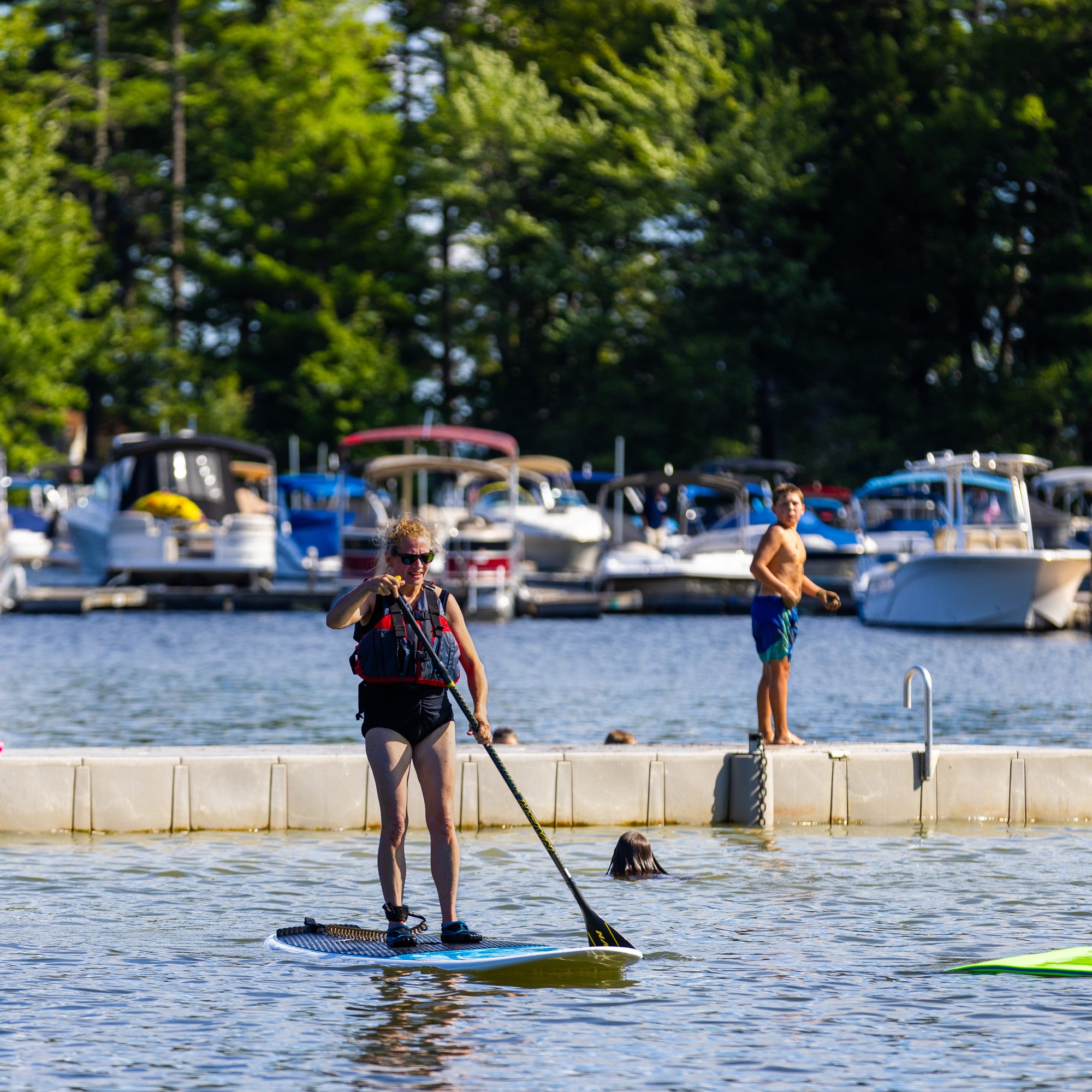 Point Sebago Resort woman on paddleboard and kid on dock