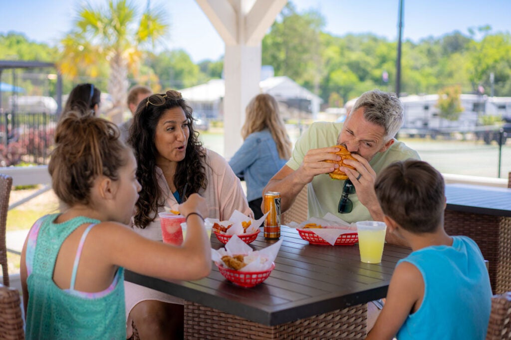 Family eating lunch at the Pool Bar at CreekFire RV Resort in Georgia.