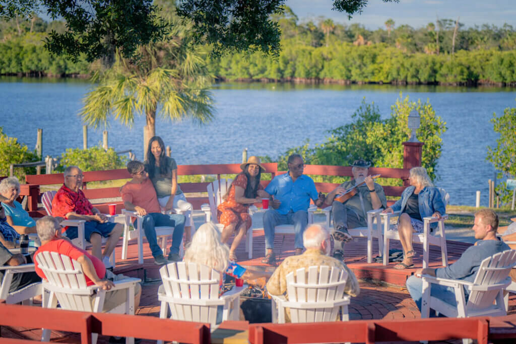Crowd of guests sitting around the fire pit at River Vista RV Park in Ruskin, Florida.