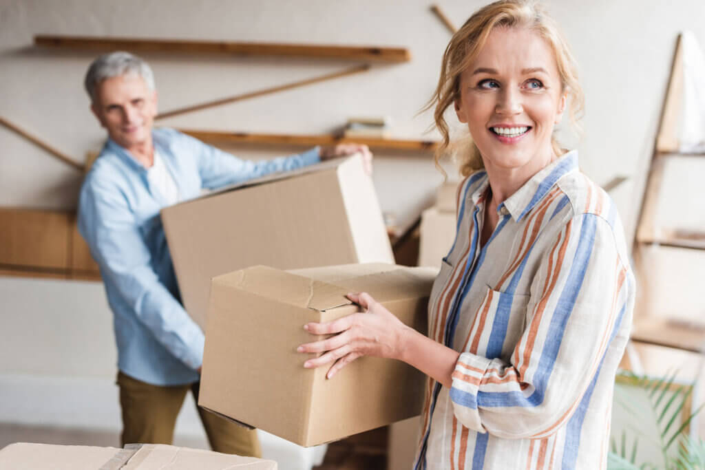 Couple moving boxes inside a new home. Credit: iStock