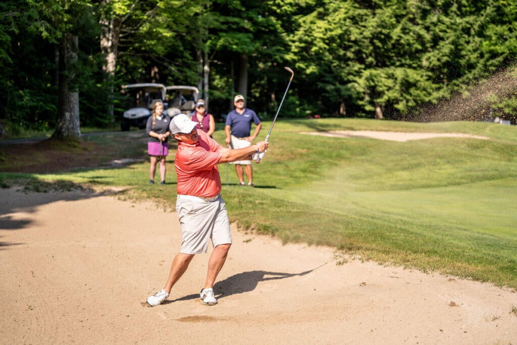 Golfer in the sand trap Point Sebago Golf Course in Casco, Maine.