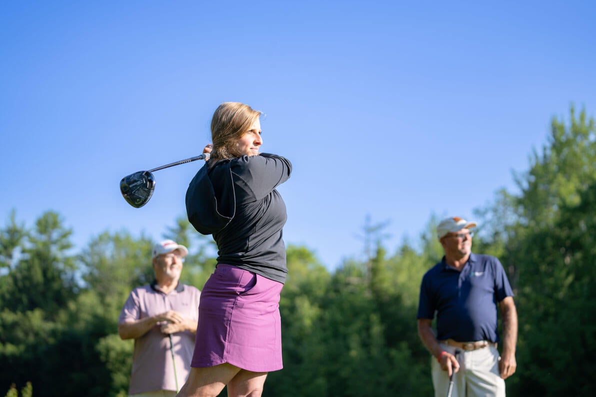 Woman teeing off at Point Sebago Golf Course in Casco, Maine.