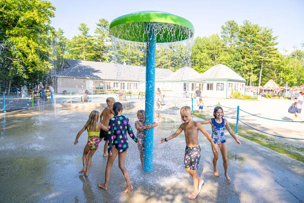 Kids running around the splash pad at Point Sebago Resort in Maine.