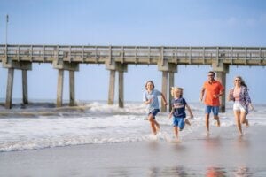 Family running along the Tybee Island Beach in Savannah, Georgia.