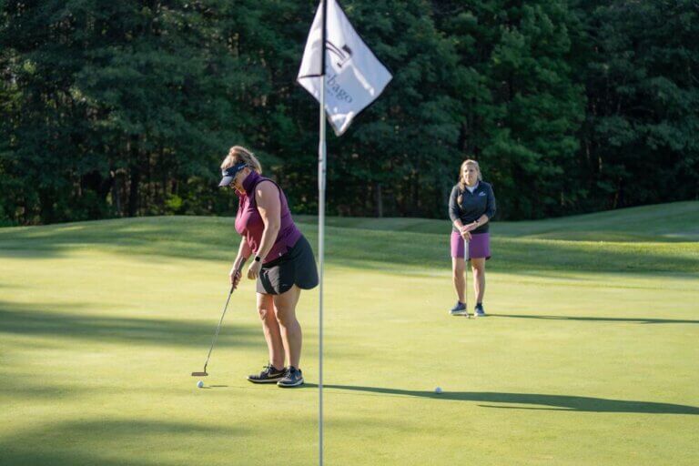 Woman putting at Point Sebago Golf Course in Casco, Maine.