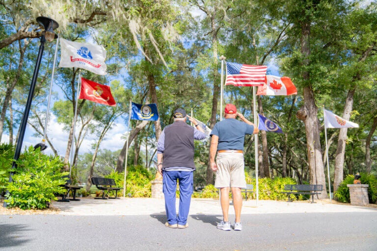 Veterans salute the American flag in Ocala, Florida at Rolling Greens Village, a 55+ retirement community.