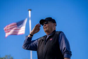A veteran salutes the flag at Rolling Greens Village, a 55+ retirement community in Florida.