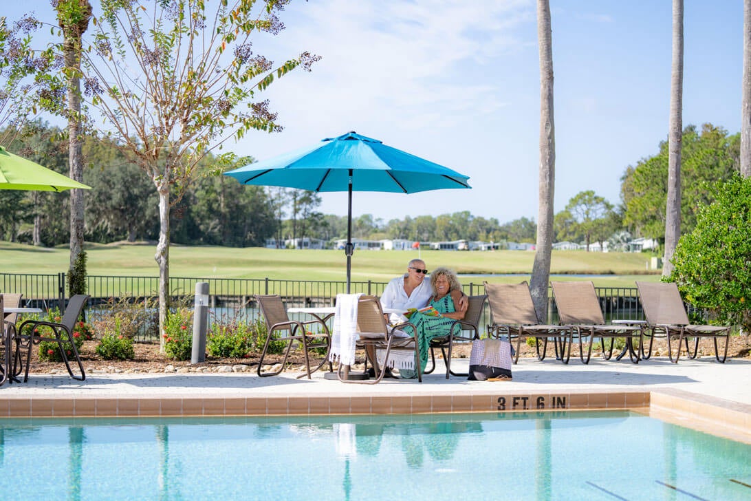 Couple sitting poolside at Cypress Lakes in Florida.