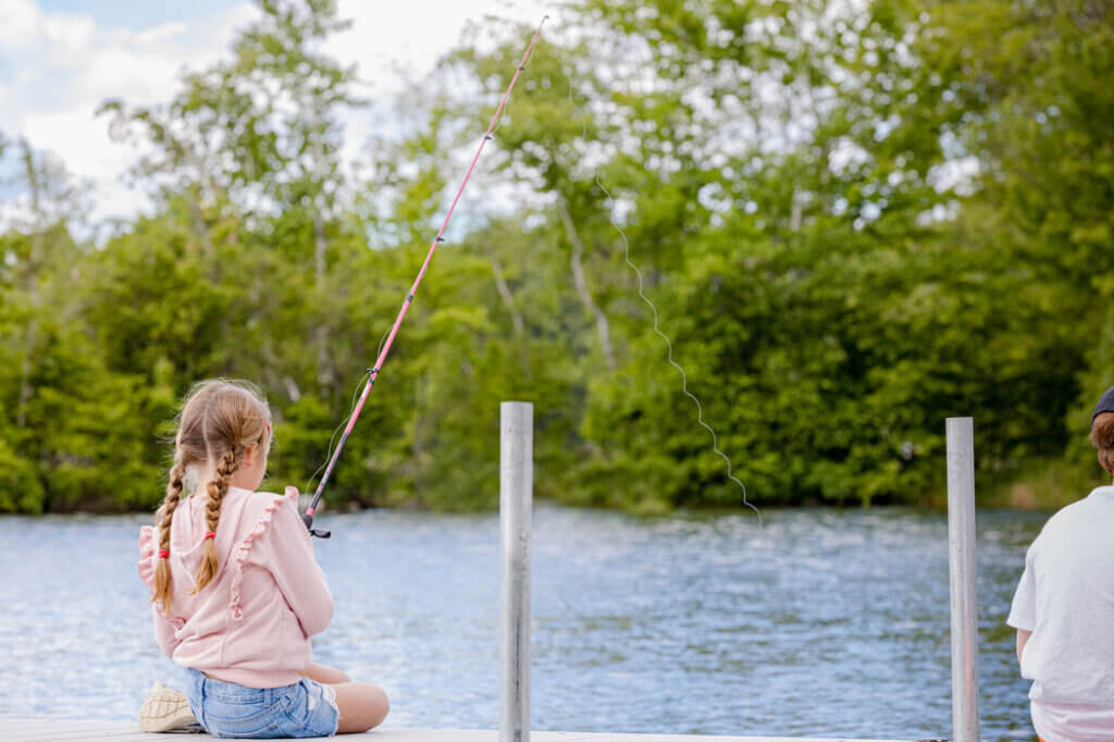 Little girl fishing on Sebago Lake in Maine at Point Sebago Resort.