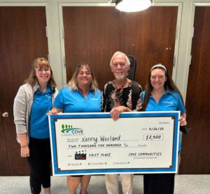 Kenny Wieland poses with his first place check after winning Cove's Got Talent