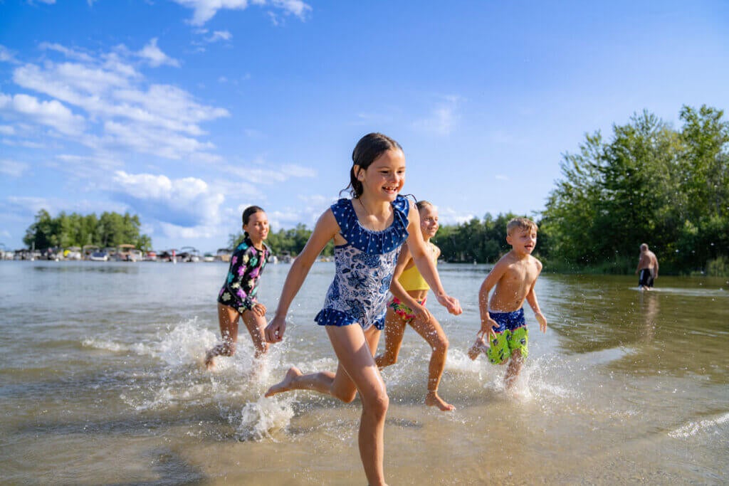 Kids running along Sebago Lake in Casco, Maine