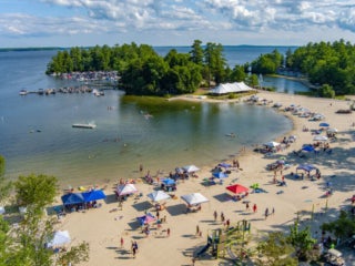 Tents lined up along the Maple Cove Beach along the shores Sebago Lake of Point Sebago Resort in Maine.