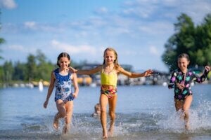 Kids running along the shoreline of Sebago Lake in Casco, Maine.