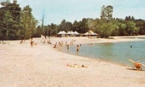 Point Sebago Resort postcard image showing the beach and Sebago Lake at Maple Cove, Maine in 1970.