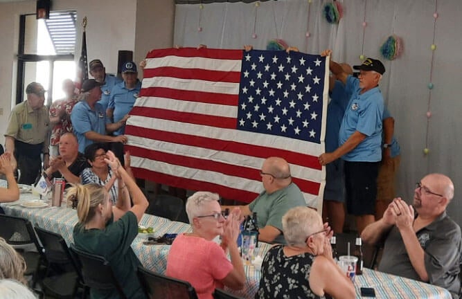 Veterans in The Meadows holding up the American flag in Tarpon Springs, Florida.