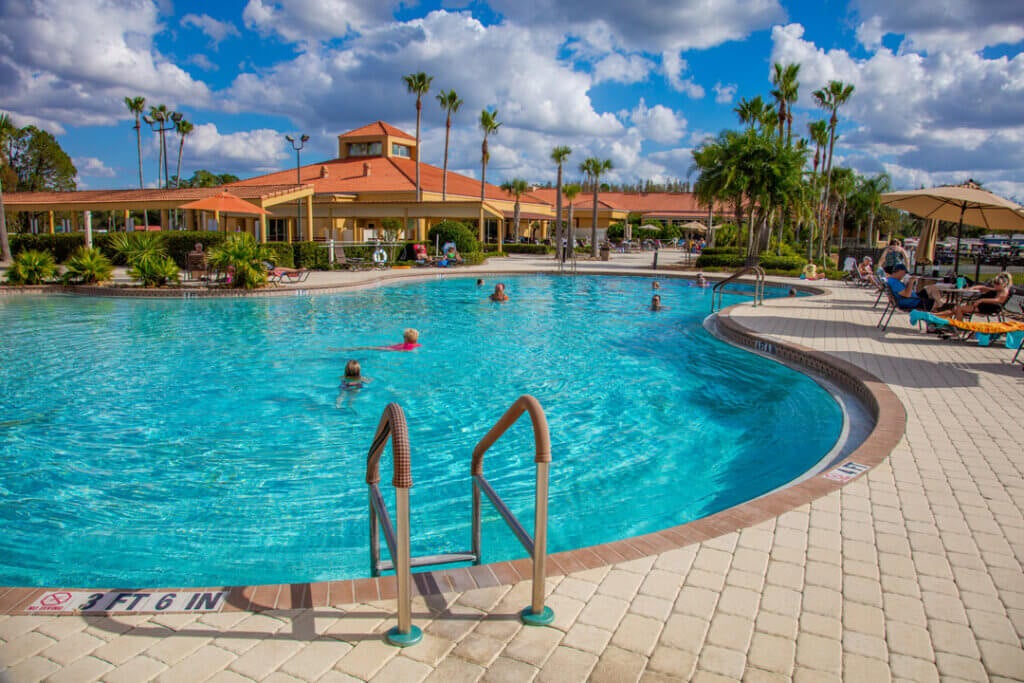 Residents lounging on the pool deck and enjoying the swimming pool at Cypress Lakes