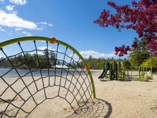 Empty playground set sitting on the beach at Sebago Lake