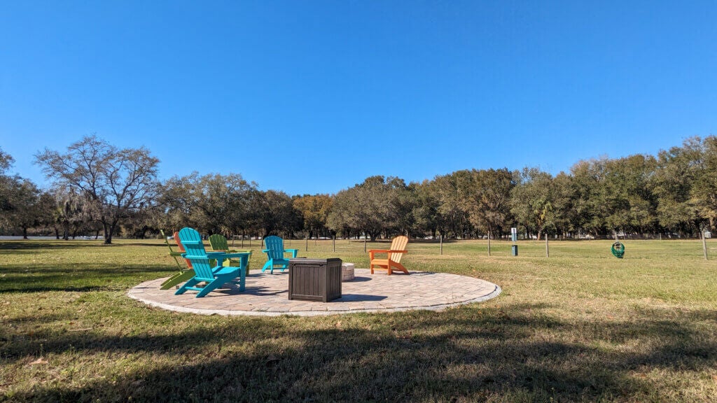 Seating around the firepit and dog park in the background at Oak Harbor RV Park