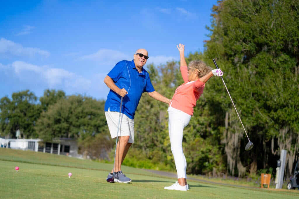 Couple celebrating whole holding golf clubs at Big Cypress Golf Club in Lakeland, Florida.