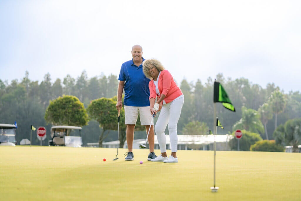 Golf_Course_Big_Cypress_LakeLand_65 Woman putting on the green at Big Cypress Golf Club in Lakeland, Florida.