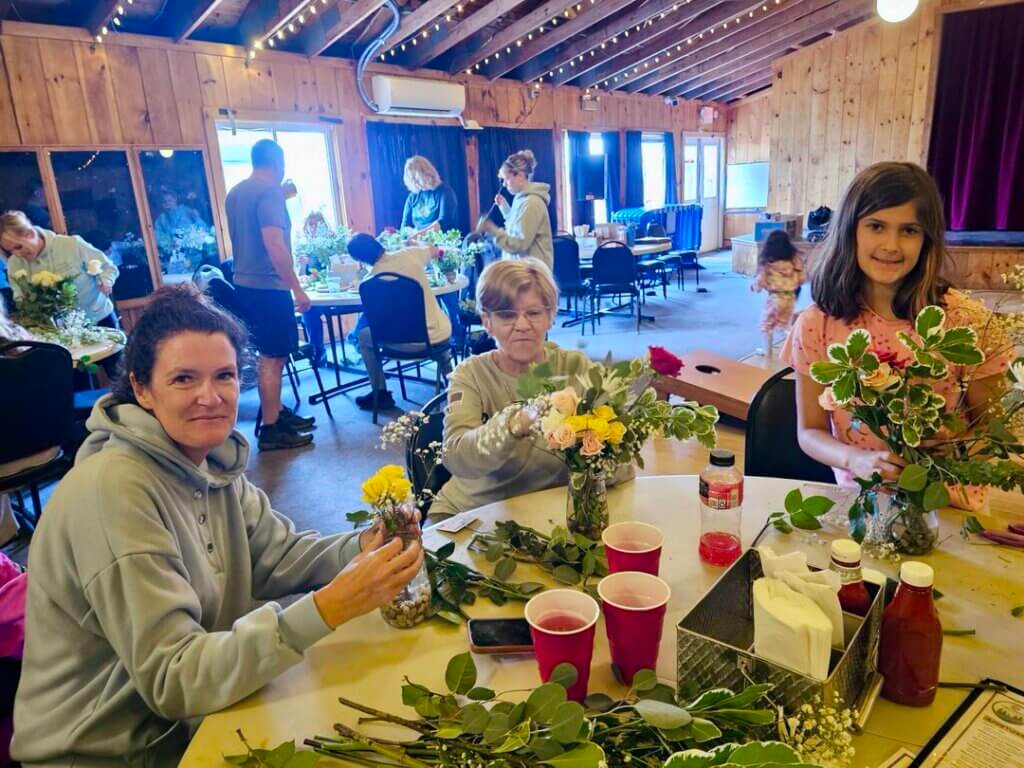 Three family members making bouquets in a Point Sebago Resort floral arrangement class in Maine.