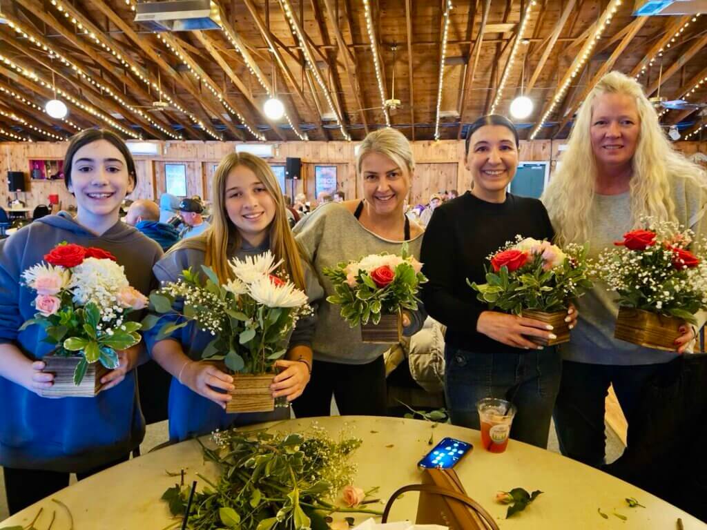 Mothers and daughters showing off their floral arrangements at Point Sebago Resort for Mother&#039;s Day.