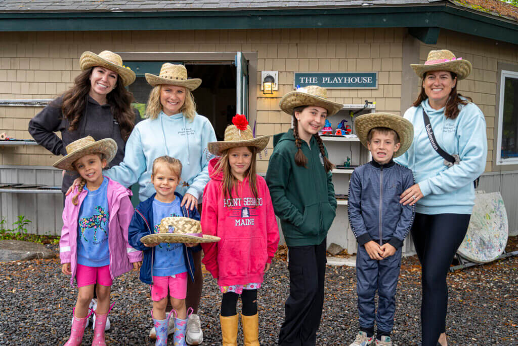 a group of women and kids showing off their cowboy hats they crafted at Point Sebago Resort in Maine.