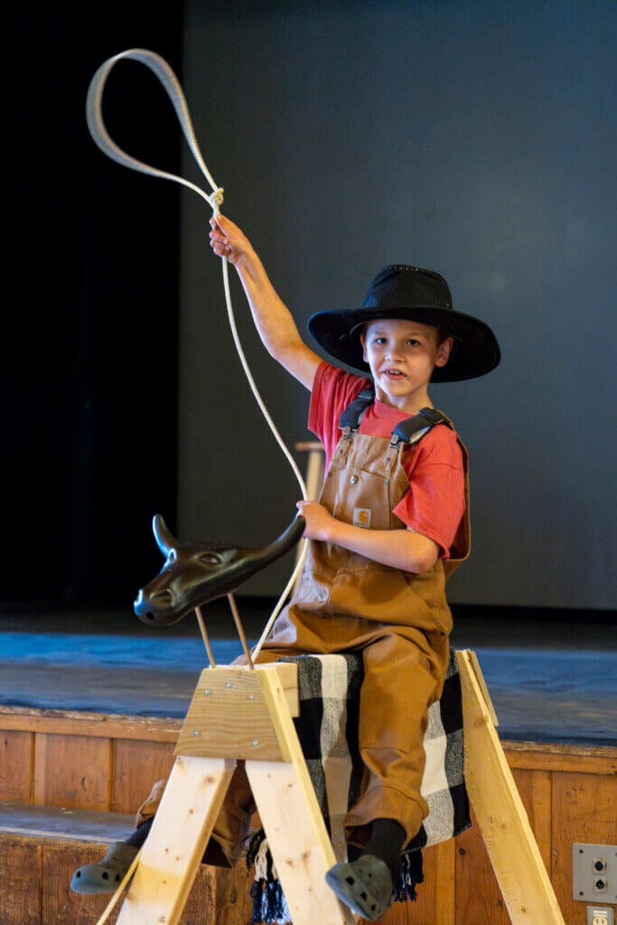 Little boy swinging his lasso during Country Western Weekend at Point Sebago Resort in Maine.