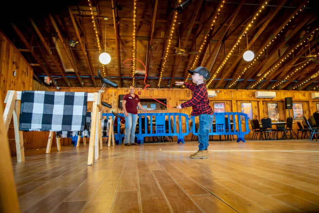Little boy swinging his lasso during Country Western Weekend at Point Sebago Resort in Maine.