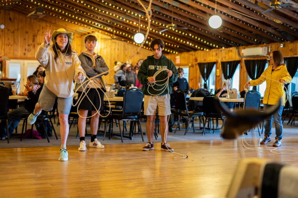 Four people learning to lasso at Point Sebago Resort during Country Western Weekend.