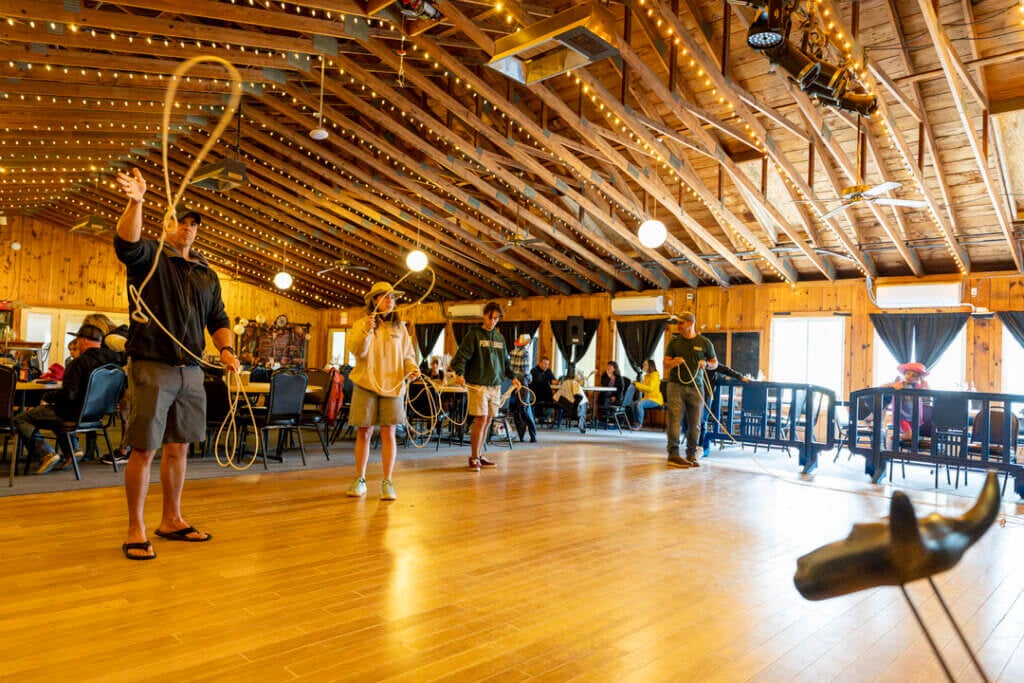 Four people learning to lasso at Point Sebago Resort during Country Western Weekend.