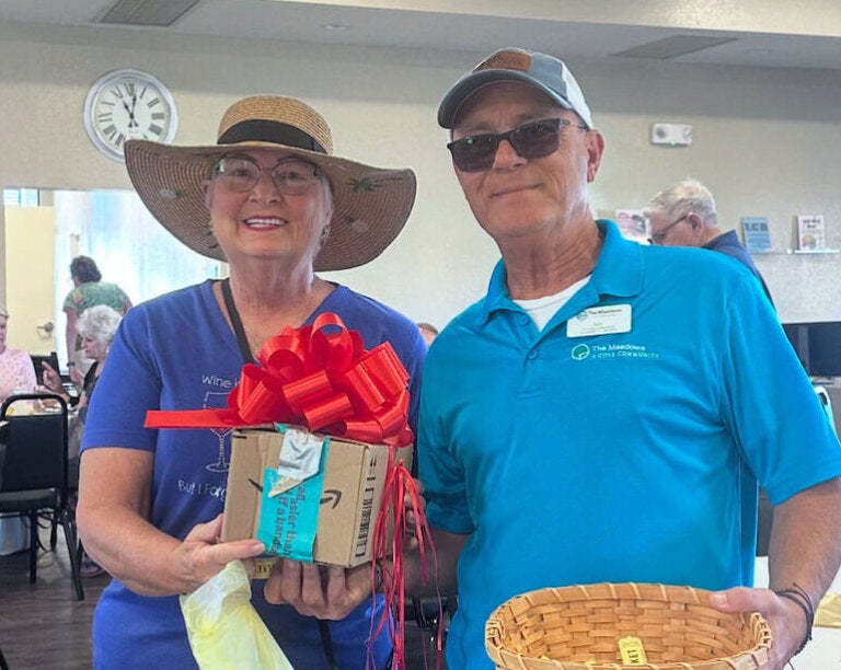 Ray Bonello, the lifestyle manager at The Meadows, poses with a resident at clubhouse event.